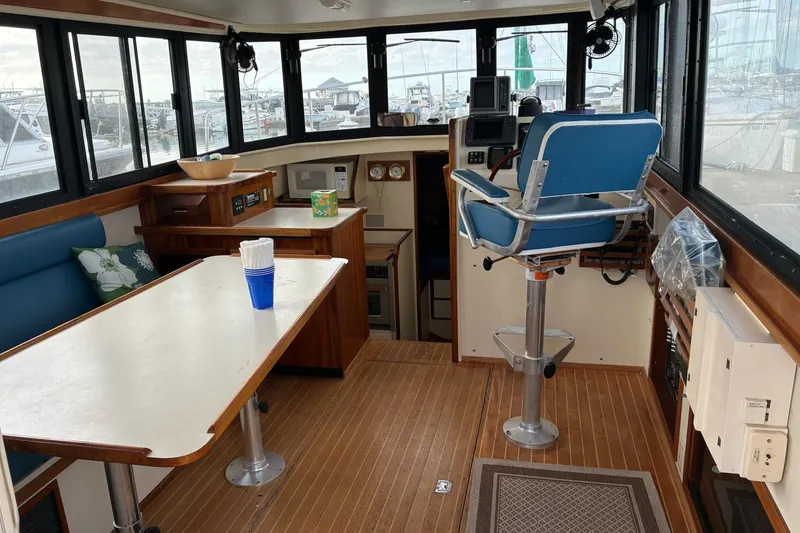 Slide: The Image of Interior of a 2003 Camano Troll boat with helm, seating, and table. - 4