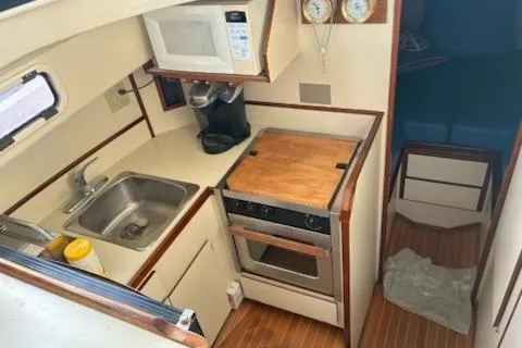 Slide: The Image of 2003 Camano Troll boat kitchen with sink, stove, and microwave. - 7