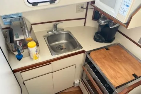 Slide: The Image of Compact kitchen in a 2003 Camano Troll boat with sink, stove, and appliances. - 9