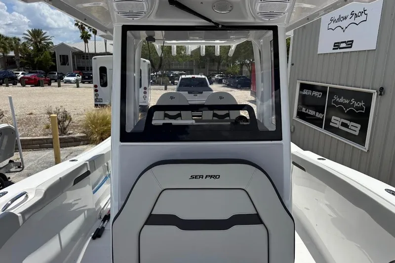 Slide: The Image of 2026 Sea Pro 262 Offshore boat interior with console and seating, displayed outdoors. - 13