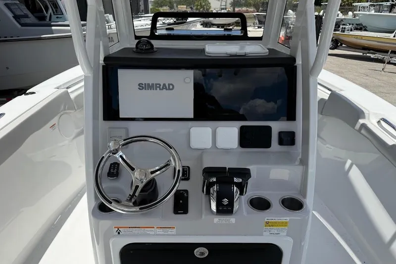 Slide: The Image of 2026 Sea Pro 262 Offshore boat dashboard with Simrad display and steering wheel. - 15