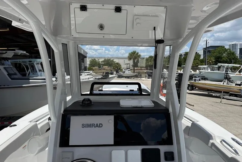 Slide: The Image of 2026 Sea Pro 262 Offshore boat dashboard with Simrad navigation system, docked outdoors. - 16