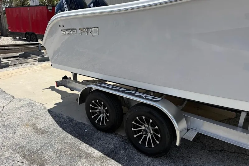 Slide: The Image of 2026 Sea Pro 262 Offshore boat on a trailer, showcasing sleek design and dual wheels. - 5