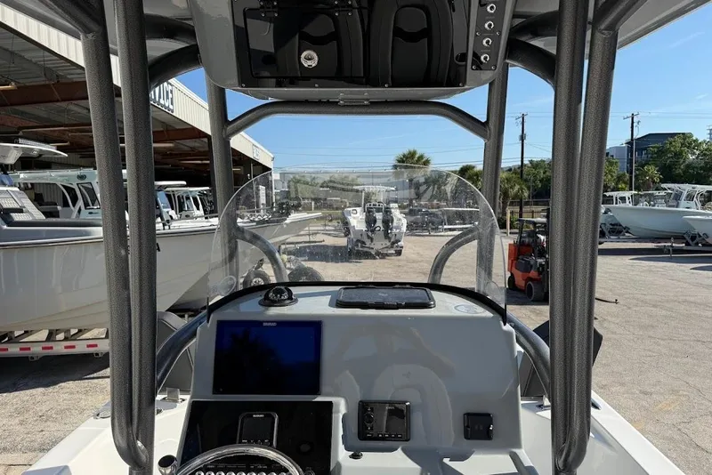 Slide: The Image of 2026 Sea Pro 250 Bay boat dashboard with navigation equipment in a marina setting. - 17