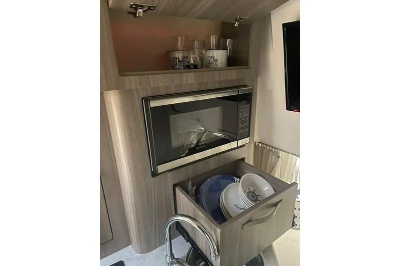 Slide: The Image of Modern kitchen area in 2020 Regal 28 Express boat with microwave and storage. - 12