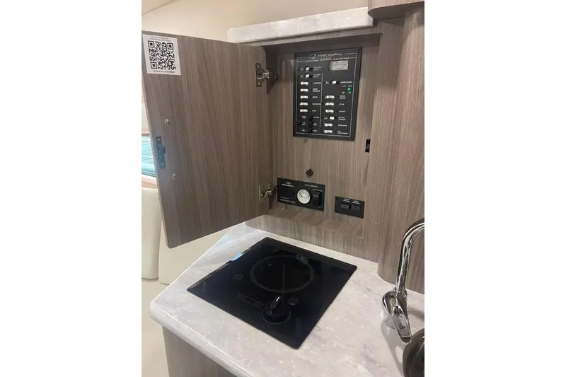 Slide: The Image of Control panel and stove in 2020 Regal 28 Express boat interior. - 13