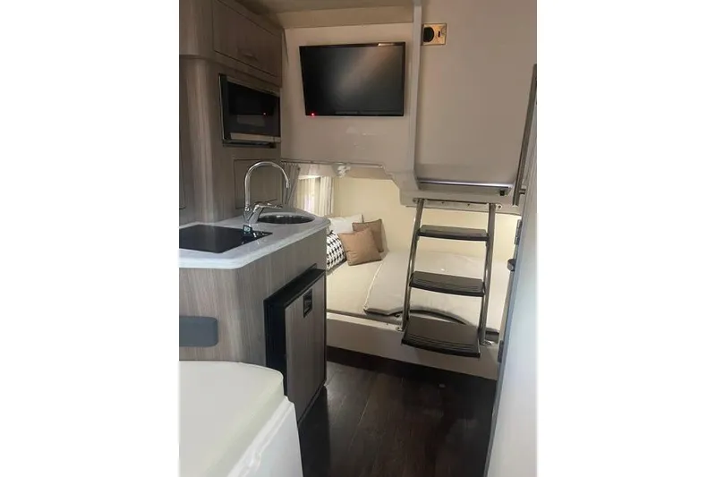 Slide: The Image of Interior of 2020 Regal 28 Express boat with kitchenette and sleeping area. - 16