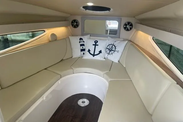 Slide: The Image of Interior of 2020 Regal 28 Express boat with beige seating and nautical-themed pillows. - 19