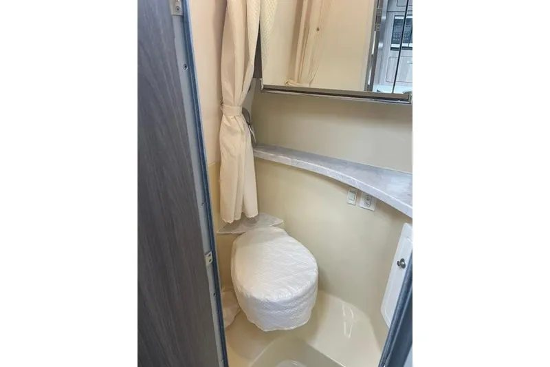 Slide: The Image of 2020 Regal 28 Express boat bathroom interior with toilet and mirror. - 22