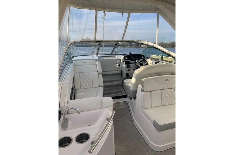 Slide: The Image of 2020 Regal 28 Express boat interior with seating and helm, docked by the water. - 6