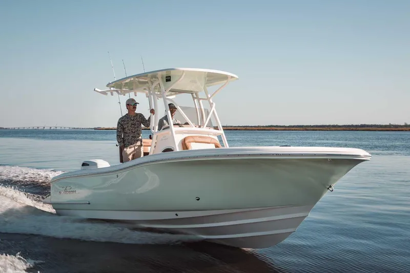 The Image of 2027 Pioneer 222 Sportfish boat cruising on calm waters under clear skies. - 1