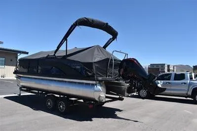 Slide: The Image of 2026 Lowe SF 212 Sport Fish pontoon boat on trailer, covered, parked outdoors. - 2