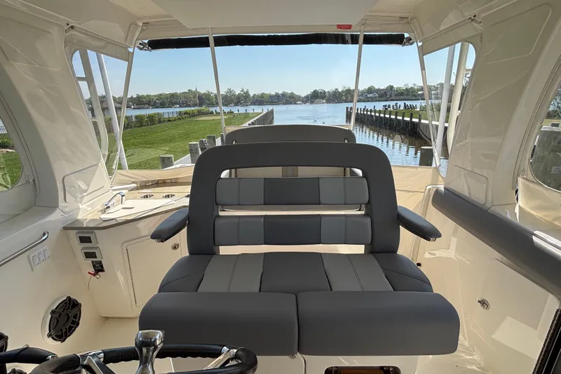 Slide: The Image of 2024 Boston Whaler 350 Realm interior with luxurious seating and scenic waterfront view. - 16