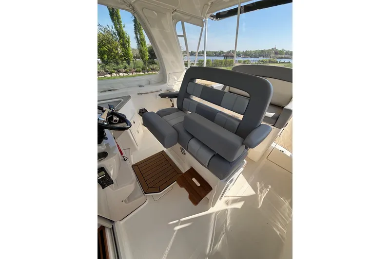 Slide: The Image of 2024 Boston Whaler 350 Realm helm seating with luxurious gray upholstery and wooden flooring. - 17