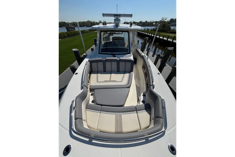 Slide: The Image of 2024 Boston Whaler 350 Realm boat with spacious seating and sleek design at dock. - 18