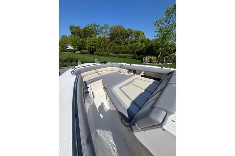 Slide: The Image of 2024 Boston Whaler 350 Realm boat interior with luxurious seating and scenic background. - 19