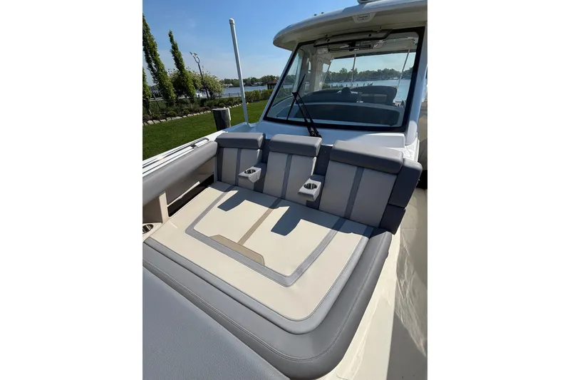 Slide: The Image of 2024 Boston Whaler 350 Realm boat interior with cushioned seating and cup holders. - 22