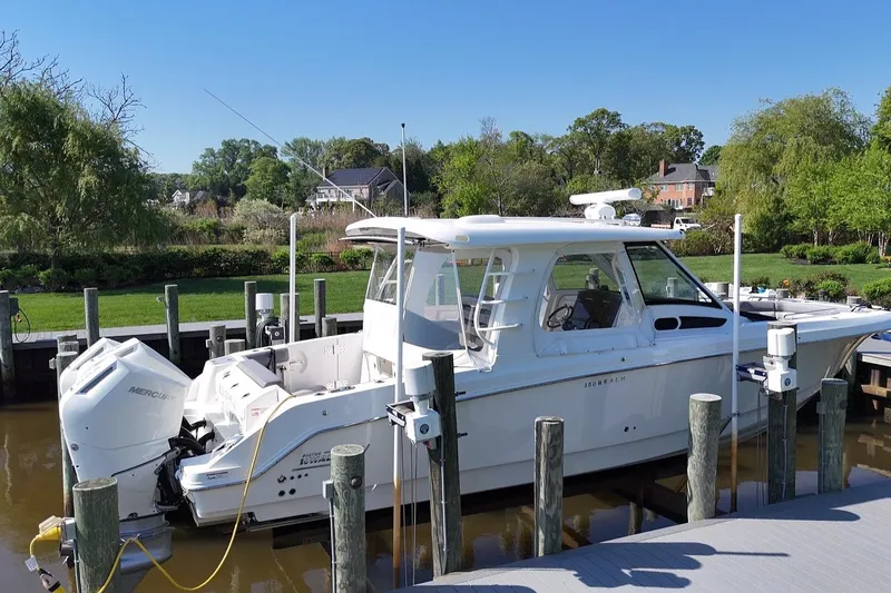 Slide: The Image of 2024 Boston Whaler 350 Realm docked, featuring sleek design and powerful Mercury engines. - 3