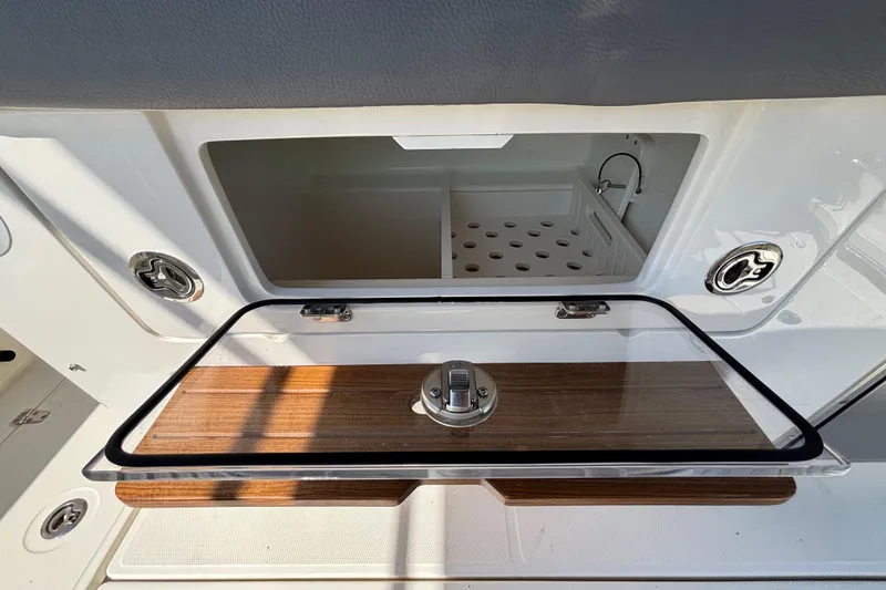 Slide: The Image of 2024 Boston Whaler 350 Realm interior storage compartment with wooden accents and modern design. - 30