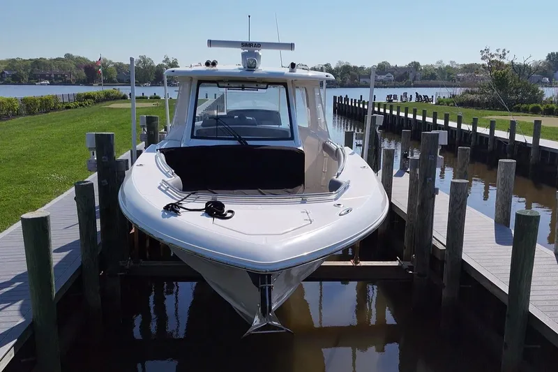 Slide: The Image of 2024 Boston Whaler 350 Realm docked at a serene waterfront location. - 4