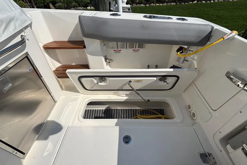 Slide: The Image of 2024 Boston Whaler 350 Realm boat interior with storage compartments and seating. - 40