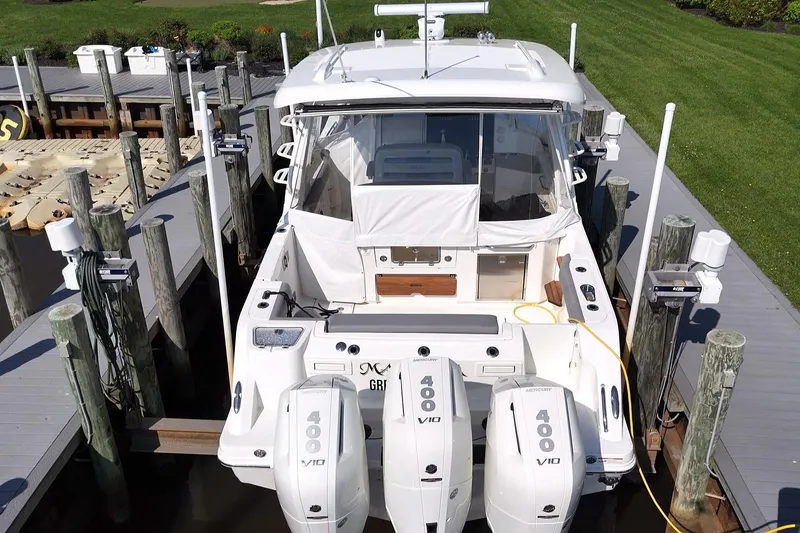 Slide: The Image of 2024 Boston Whaler 350 Realm docked, featuring triple Mercury 400 V10 engines. - 5