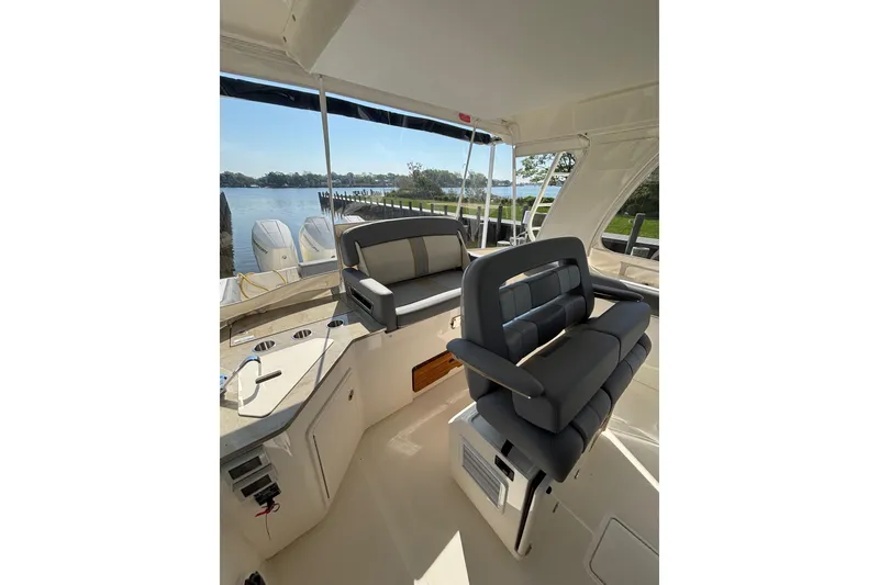 Slide: The Image of 2024 Boston Whaler 350 Realm interior with seating and scenic water view. - 8