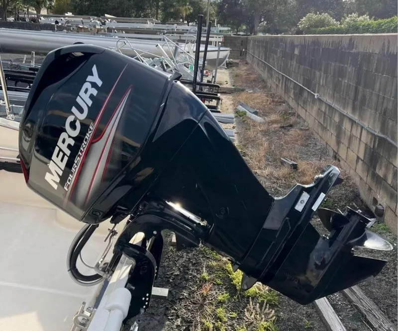 Slide: The Image of A Mercury outboard motor is attached to a boat situated on a dry, grassy area. - 6
