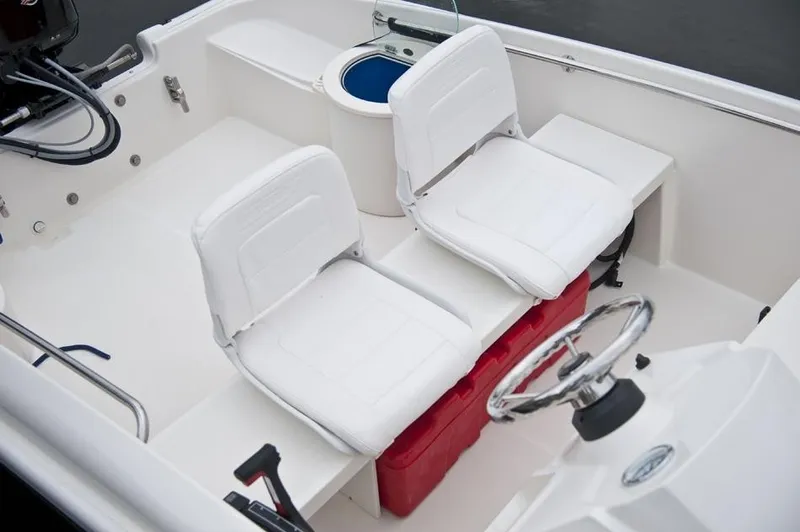 Slide: The Image of The image shows the cockpit of a 2018 Boston Whaler 150 Super Sport with two white seats. - 31