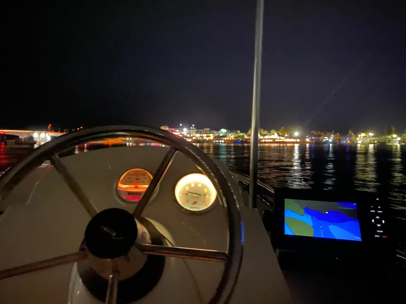 Slide: The Image of The cockpit of a 2018 Boston Whaler 150 Super Sport at night, with illuminated gauges and a navigation screen. - 17