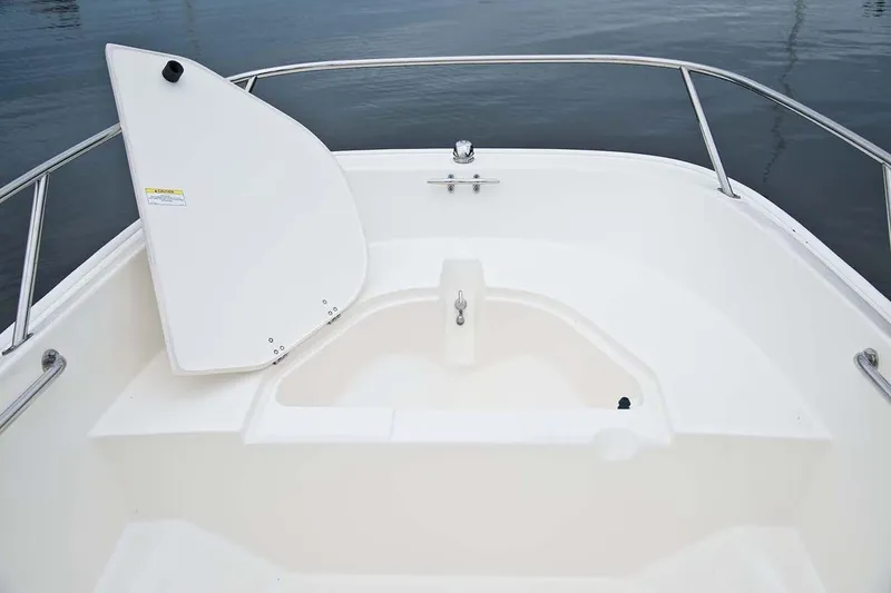Slide: The Image of The image shows the bow area of a 2018 Boston Whaler 150 Super Sport with storage space. - 33
