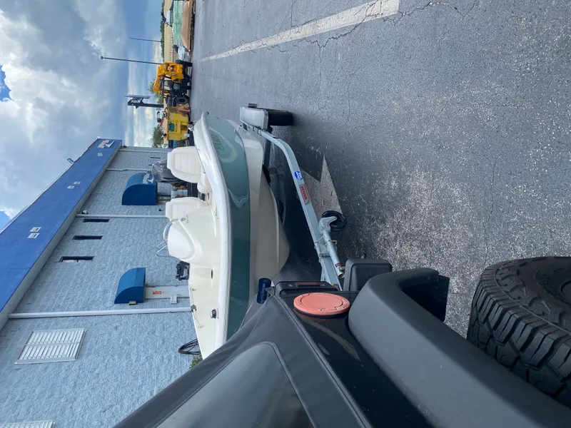 Slide: The Image of A 2018 Boston Whaler 150 Super Sport on a trailer, parked beside a building. - 9