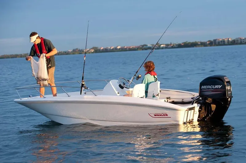 Slide: The Image of A 2018 Boston Whaler 150 Super Sport on calm water with two people fishing. - 28