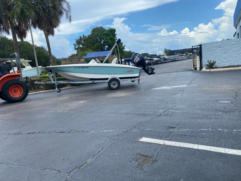 Slide: The Image of A 2018 Boston Whaler 150 Super Sport on a trailer, being towed by a tractor. - 8