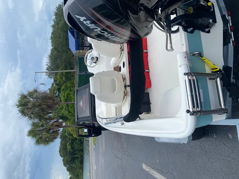 Slide: The Image of A 2018 Boston Whaler 150 Super Sport on a trailer. It features a Mercury outboard motor. - 10