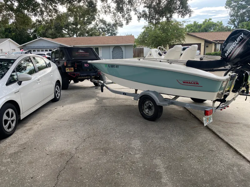 Slide: The Image of A 2018 Boston Whaler 150 Super Sport on a trailer in a driveway. - 12