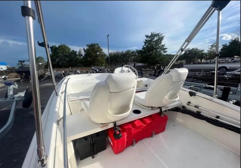 Slide: The Image of The image shows the cockpit of a 2018 Boston Whaler 150 Super Sport with white seats and a red container. - 3