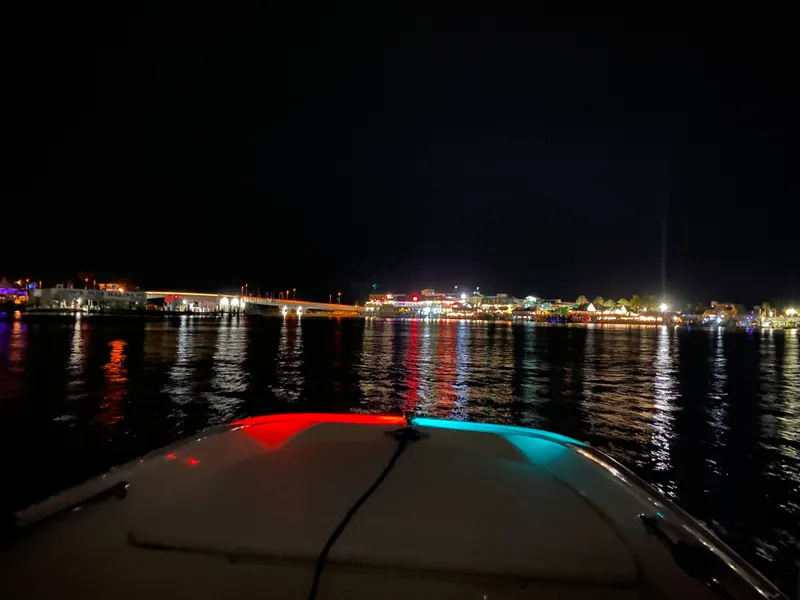 Slide: The Image of A 2018 Boston Whaler 150 Super Sport on illuminated waters at night. - 18
