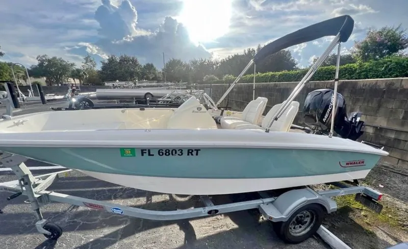 The Image of A 2018 Boston Whaler 150 Super Sport on a trailer, featuring two seats and an outboard motor. - 0