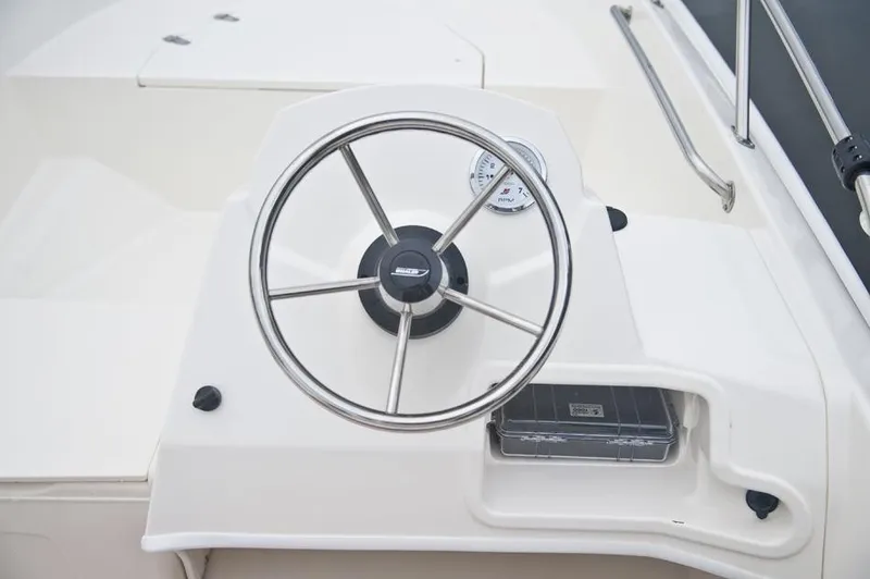 Slide: The Image of The image shows the helm of a 2018 Boston Whaler 150 Super Sport. - 30