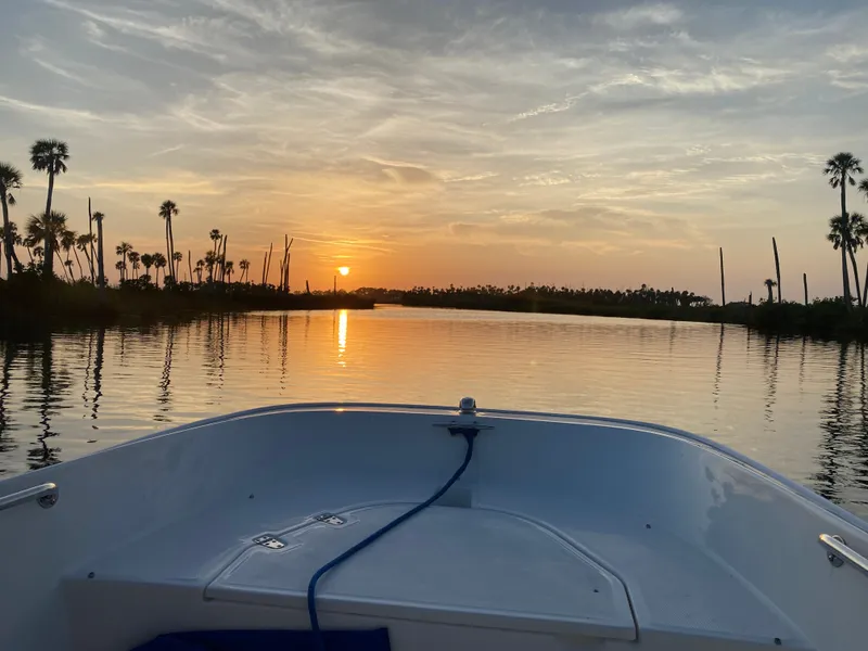 Slide: The Image of A 2018 Boston Whaler 150 Super Sport on calm waters at sunset. - 20