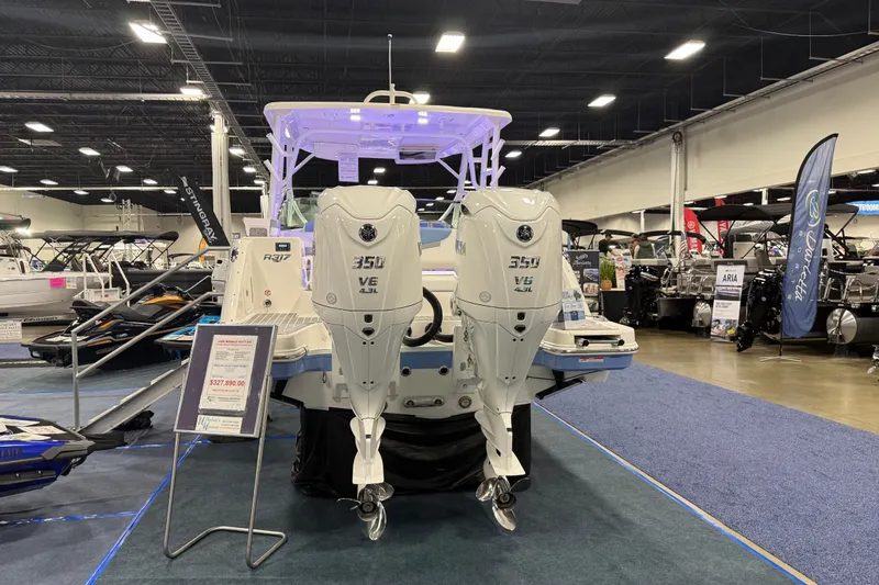 Slide: The Image of 2026 Robalo R317 Dual Console boat with twin 350 V6 engines displayed indoors. - 6