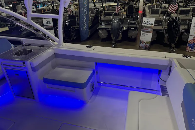 Slide: The Image of 2026 Robalo R317 Dual Console boat interior with blue LED lighting and seating area. - 9