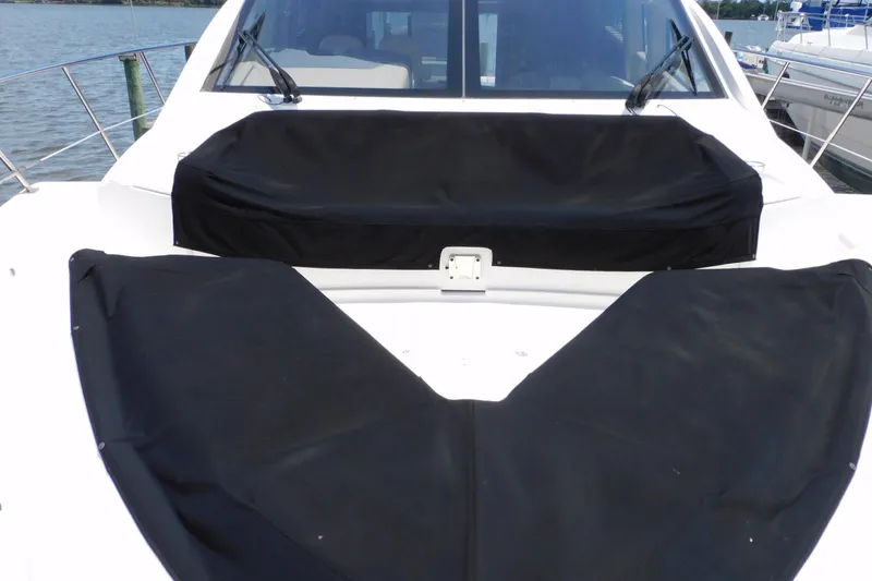 Slide: The Image of 2019 Sea Ray L550 yacht with black covers on deck, docked by the water. - 10