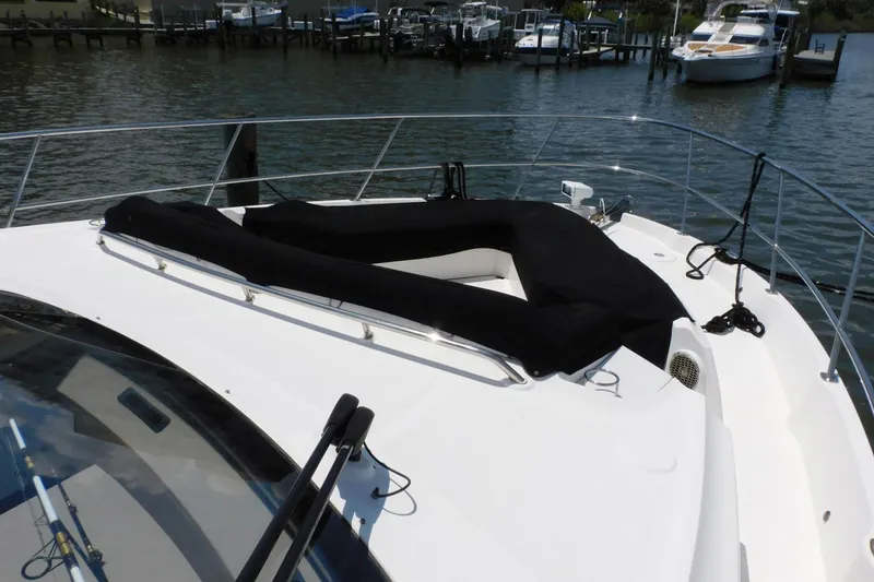 Slide: The Image of 2019 Sea Ray L550 yacht bow with black sunpad, docked in marina. - 12