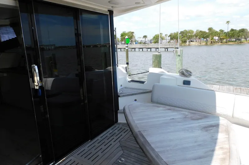 Slide: The Image of 2019 Sea Ray L550 yacht deck with seating, overlooking a serene waterfront view. - 15