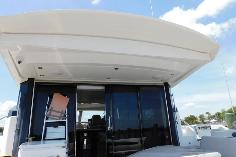 Slide: The Image of 2019 Sea Ray L550 yacht with sleek exterior and spacious deck under clear skies. - 16