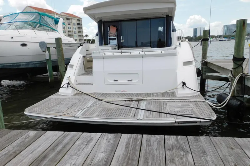 Slide: The Image of 2019 Sea Ray L550 yacht docked at marina, showcasing spacious rear deck. - 2