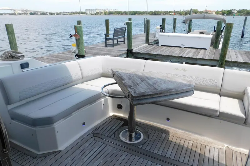 Slide: The Image of 2019 Sea Ray L550 yacht with elegant seating and wooden table on deck. - 24