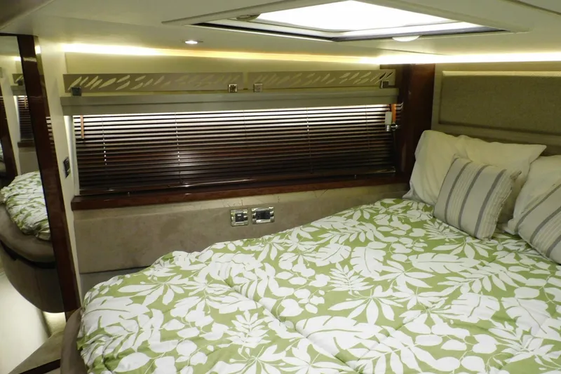 Slide: The Image of Luxurious 2019 Sea Ray L550 yacht bedroom with floral bedding and elegant wood accents. - 32